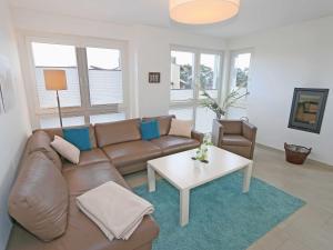 a living room with a brown couch and a table at Strandvilla Baabe - WG 12 mit Meerblick, Kamin, Sauna, Whirlpool in Baabe