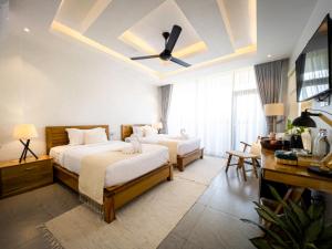 a bedroom with two beds and a ceiling fan at Montagne Boutique in Kampot