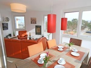 sala de estar con mesa y sofá en Strandvilla Baabe F 635 WG 26 mit Meerblick, Kamin, Sauna, Whirlpool en Baabe