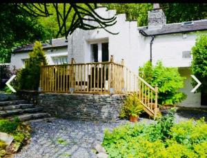 a house with a wooden deck in the yard at Dove Cot country cottage Ambleside in Ambleside