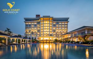 a hotel with a large building in the background at Gold Coast Hotel Resort & Spa in Dong Hoi