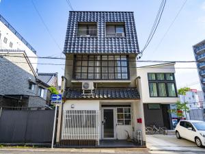 ein Haus mit einem schwarz-weißen Dach in der Unterkunft Usatsuno Osu in Nagoya