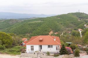 a white house with an orange roof on a hill at Vista de Montana Meteora II in Vlacháva