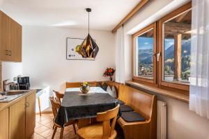 una cucina e una sala da pranzo con tavolo e sedie di Villa Erina App A a Ortisei