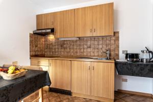una cocina con armarios de madera y un bol de fruta en Villa Erina App B, en Ortisei