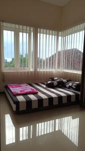 uma cama grande num quarto com uma janela grande em PAPADAAN Homestay Syariah Batu em Karangploso