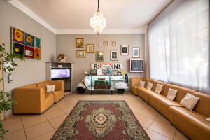 a living room with two couches and a tv at Hotel Ausonia in Rimini