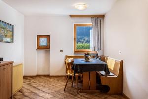 een eetkamer met een tafel en stoelen en een raam bij Villa Erina App A2 in Ortisei
