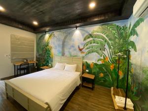 een slaapkamer met een groot bed en een muurschildering bij Cerf Volant Soc Son in Hanoi