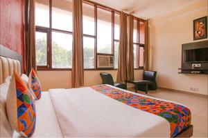 um quarto de hotel com uma cama e uma televisão em FabHotel Town Pride em Sohāna