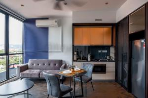 eine Küche und ein Wohnzimmer mit einem Tisch und einem Sofa in der Unterkunft Scarletz Mana-Mana Suites KLCC in Kuala Lumpur