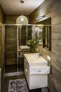 a bathroom with a white sink and a mirror at Apartamenty Alcatraz z Jacuzzi in Karpacz