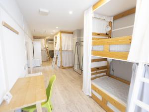 Zimmer mit einem Tisch und einem Etagenbett in der Unterkunft Usatsuno Osu in Nagoya