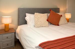 a bedroom with a white bed with two lamps at K2Cottages 