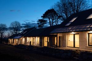 a row of houses with their lights on at night at K2Cottages 