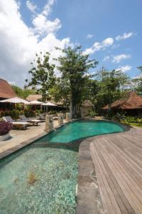 a swimming pool in a resort with a wooden deck at Kayu Mama Resort and Spa in Uluwatu