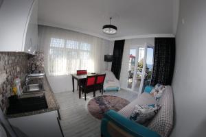 eine Küche und ein Wohnzimmer mit Sofa und Tisch in der Unterkunft Delpina APART&OTEL in Pazar