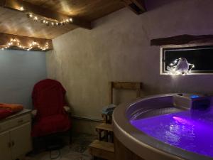 カプレーゼ・ミケランジェロにあるLa casina del preteのバスルーム(紫色の照明付きのバスタブ、椅子付)