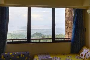 Dormitorio con ventana con cama y vistas en Taal Lake Staycation Juliet's Vacation in Splendido Free Parking Netflix en Tagaytay