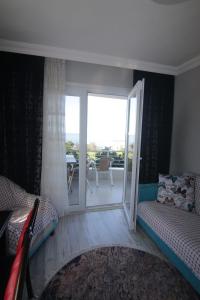 a bedroom with two beds and a sliding door with a balcony at Delpina APART - Doğa içinde deniz manzaralı in Pazar