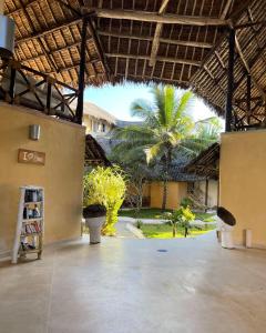 a large courtyard with a building with a palm tree at Mawe Zuri Resort in Watamu