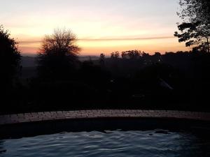 a sunset over a swimming pool in a yard at King's Hill in Hilton