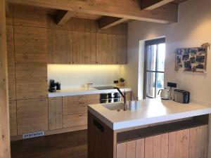 a kitchen with wooden cabinets and a sink and a counter at Mountain chalet in Kořenov