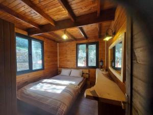 a small room with a bed in a log cabin at Panurlawoodenhouse özel havuz& sauna mavi in Urla