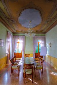 ロンカーデにあるRelais Villa Selvaticoの天井のある客室で、テーブルと椅子が備わります。