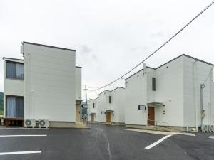 佐世保的住宿－Rakuten STAY HOUSE x WILL STYLE Sasebo 106，街道上一排白色的建筑