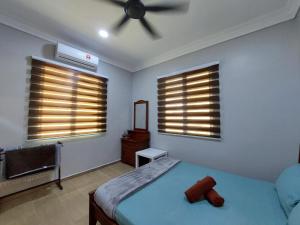 a bedroom with a bed and a ceiling fan at NurHumaira Homestay in Pantai Cenang