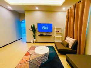un salon avec un canapé et une télévision dans l'établissement NurHumaira Homestay, à Pantai Cenang 3 autres photos