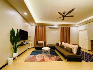 a living room with a couch and a ceiling fan at NurHumaira Homestay in Pantai Cenang