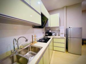 a small kitchen with a sink and a refrigerator at NurHumaira Homestay in Pantai Cenang