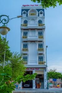 um edifício branco com um cartaz em Hotel Phạm Gia Phan Thiết em Phan Thiet