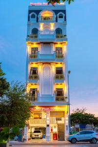 Hotel Phạm Gia Phan Thiết في فان ثيت: مبنى طويل وبه سيارات متوقفة أمامه