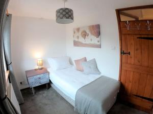Schlafzimmer mit einem Bett und einer Holztür in der Unterkunft Baker's Cottage, Urban Spa and Garden Bar in Evesham