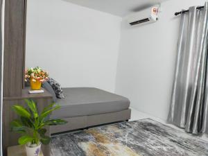 a bedroom with a bed and a plant and a window at D'Port DicksonMuslimOnly Homestay in Port Dickson