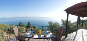 a table and chairs on a balcony with a view of the ocean at Xigia hideaway - panoramic sea view house in Zakynthos Town
