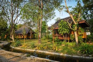 a house in the jungle with a pond in front at Baan Krating Pai Resort - SHA Plus in Pai