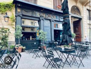 una cafetería al aire libre con mesas, sillas y sombrilla en southsidehouse, en Nápoles