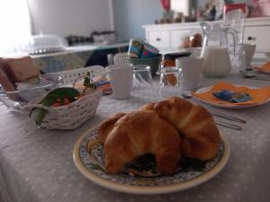 uma mesa com um prato com um croissant em Dimora Fraula Guest House em Agrigento