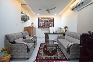 a living room with two couches and a table at MAHASRI Studio Apartments- Brand New Fully Furnished Air Conditioned Studio Apartments in Tirupati