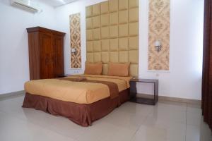 una camera da letto con un letto grande con una grande testiera di Griya Limasan Gunung Kidul a Wonosari