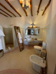 a bathroom with two toilets and a sink at Mawe Zuri Resort in Watamu
