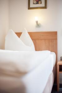 a bed with white sheets and a wooden headboard at TM Hotel Dortmund Airport in Holzwickede