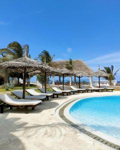 een resort met een zwembad, stoelen en parasols bij Mawe Zuri Resort in Watamu