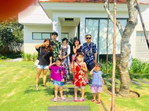 a group of people standing in front of a house at Ocean Luxury Villas Danang in Da Nang