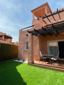 a patio with a table and chairs on a lawn at Jardín privado # Netflix # 500m de la playa in Vera