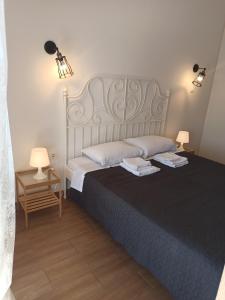 a bedroom with a large bed with two lamps on it at Atlas_Endless Blue Apartment in Loutraki